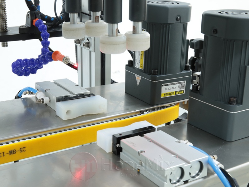 Close-Up-Of-Automatic-Cap-Tightening-Unit-On-Honemix-Capping-Machine